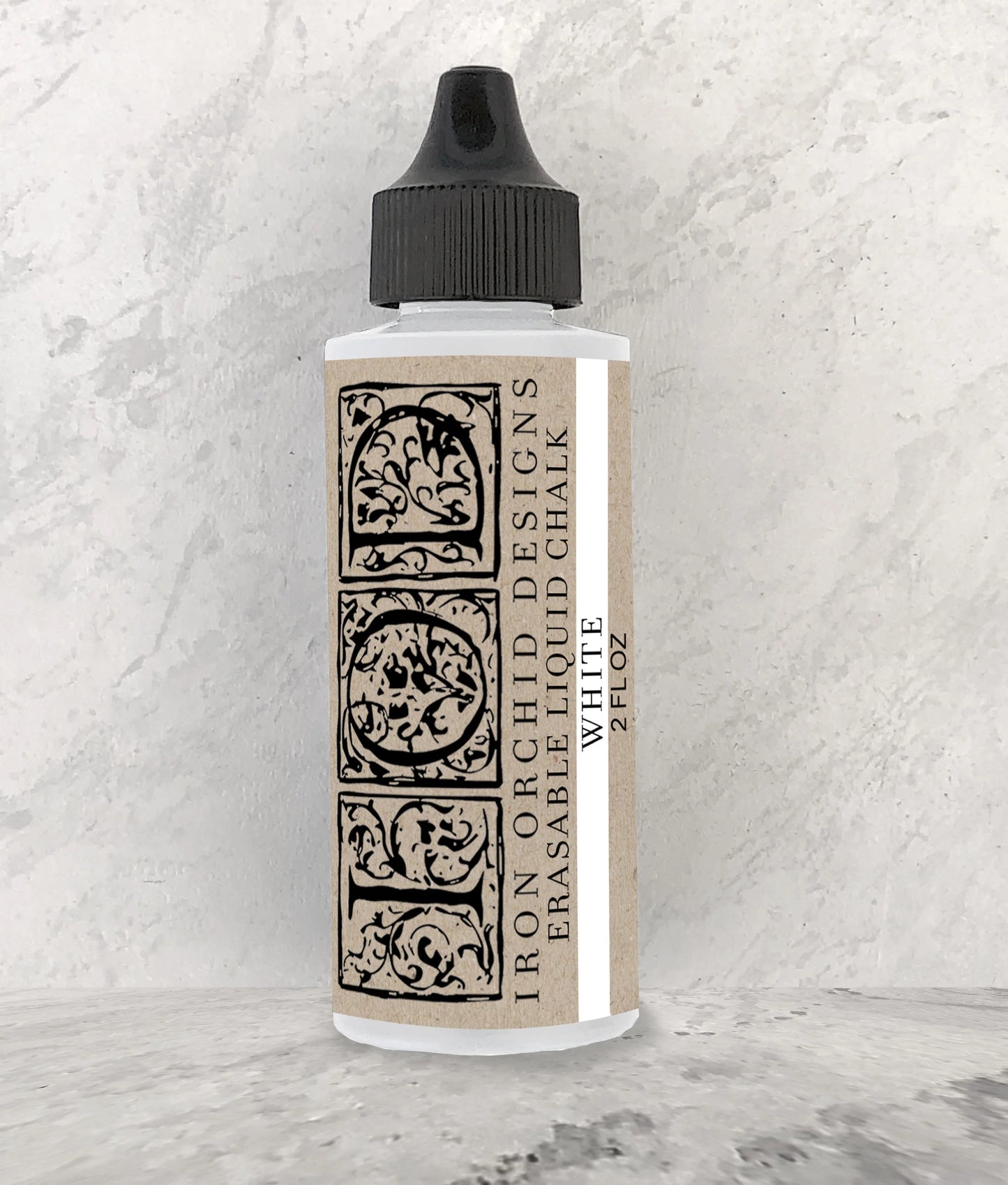 Bottle of Iron Orchid Designs liquid chalk on a textured white background