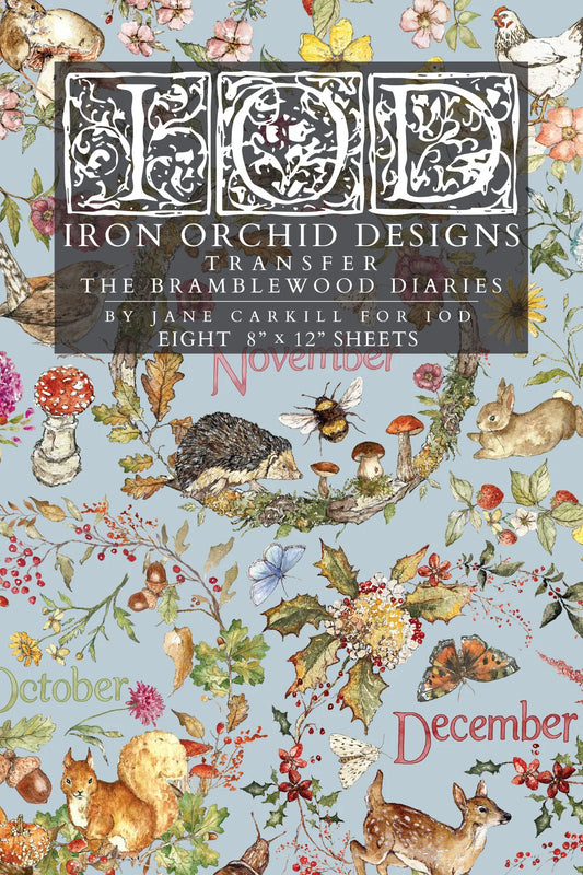 A flat lay of a transfer paper sheet featuring autumn and woodland illustrations, labeled 'IOD Iron Orchid Designs Transfer The Bramblewood Diaries' with months October, November, and December visible.