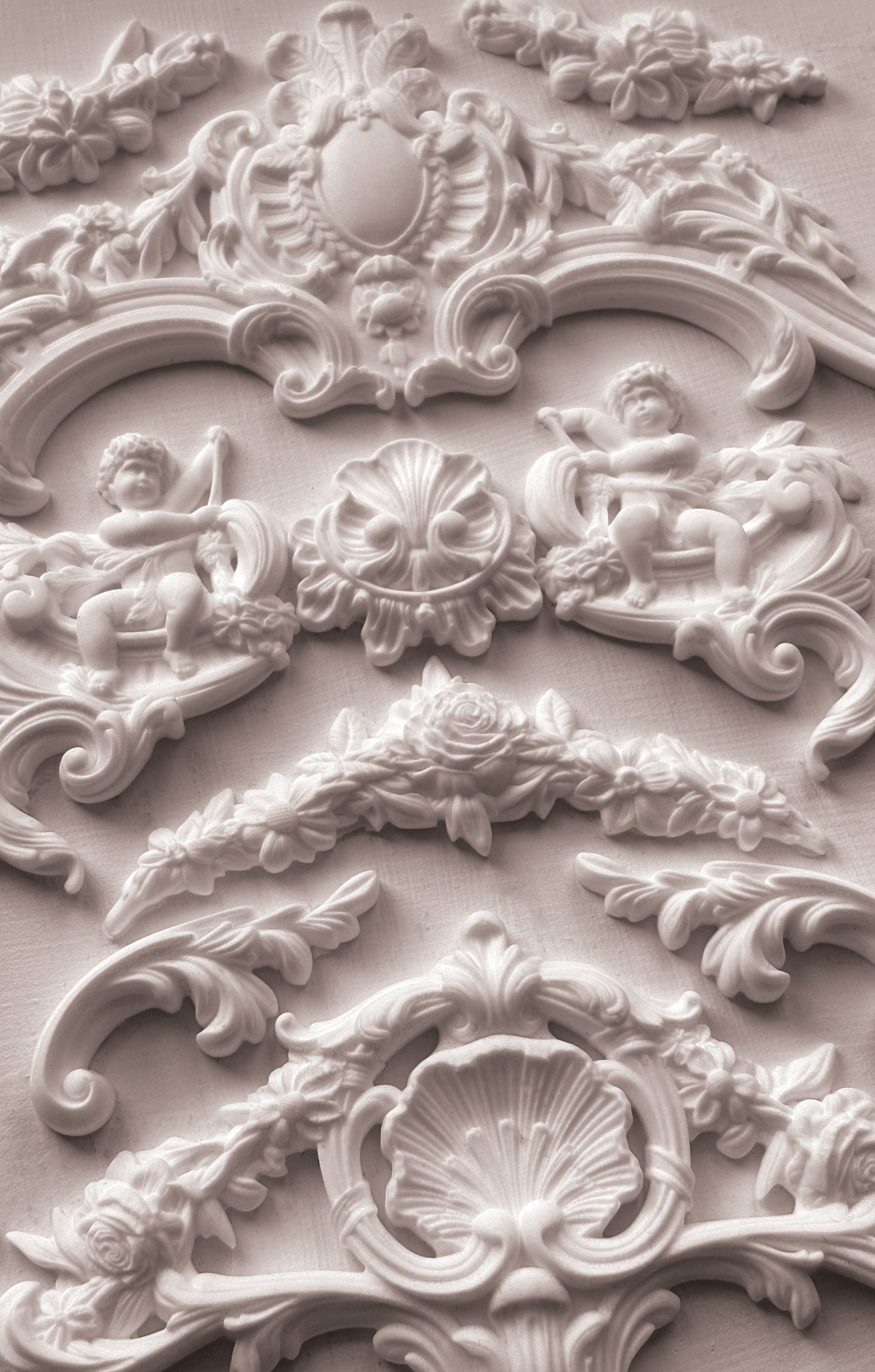 Close-up of ornate decorative stucco work with cherubs and shell designs.