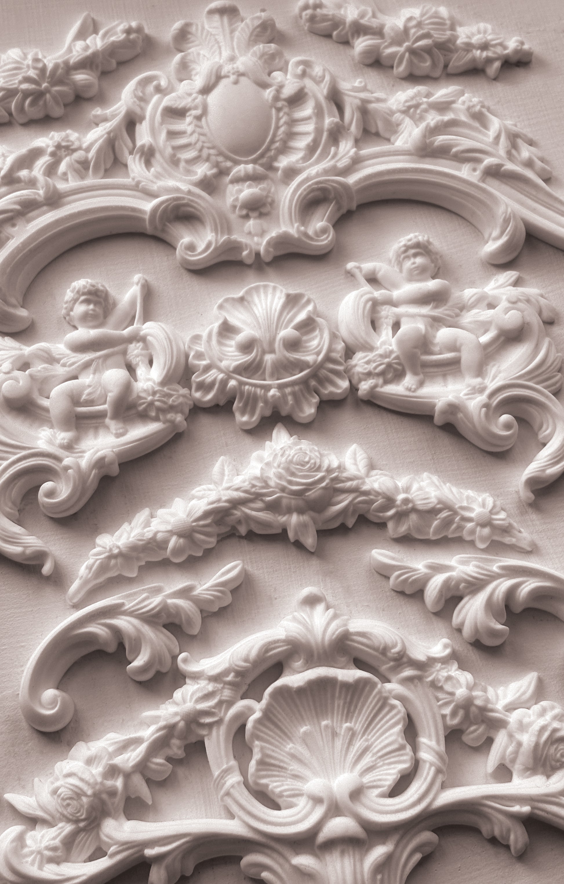 Close-up of ornate decorative stucco work with cherubs and shell designs.