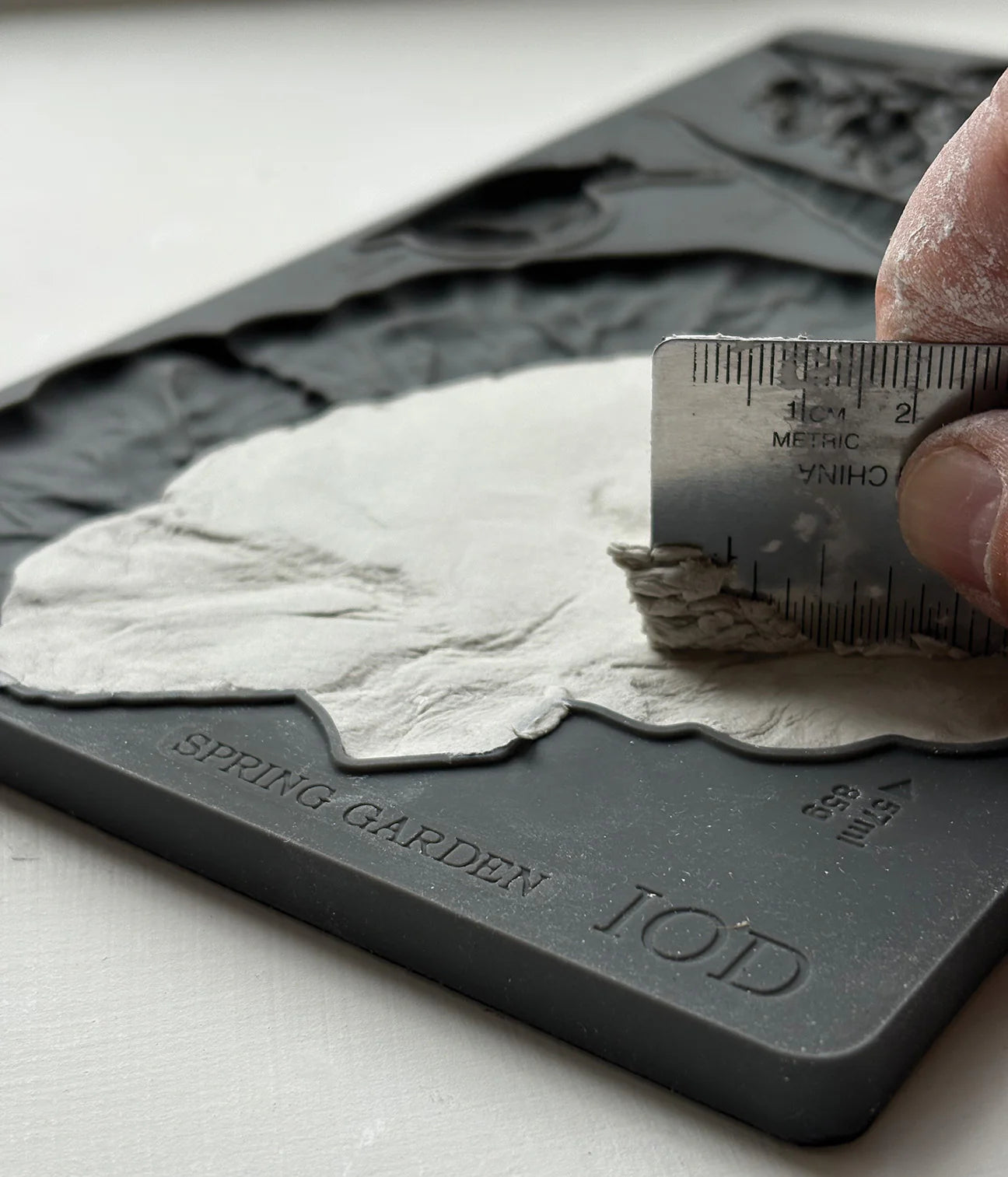 Hand using a ruler to measure a topographic map of Spring Garden by TOD.