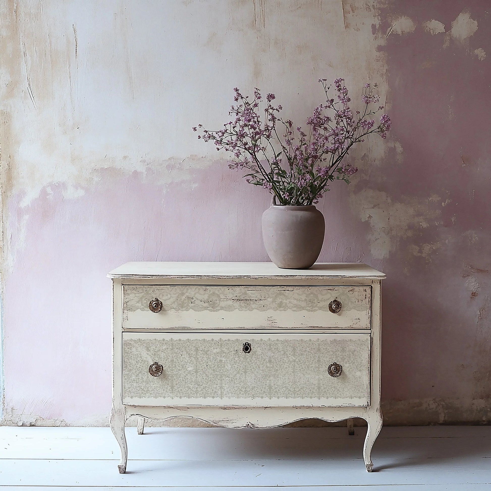 Vintage-style dresser with a vase of flowers against a textured wall.