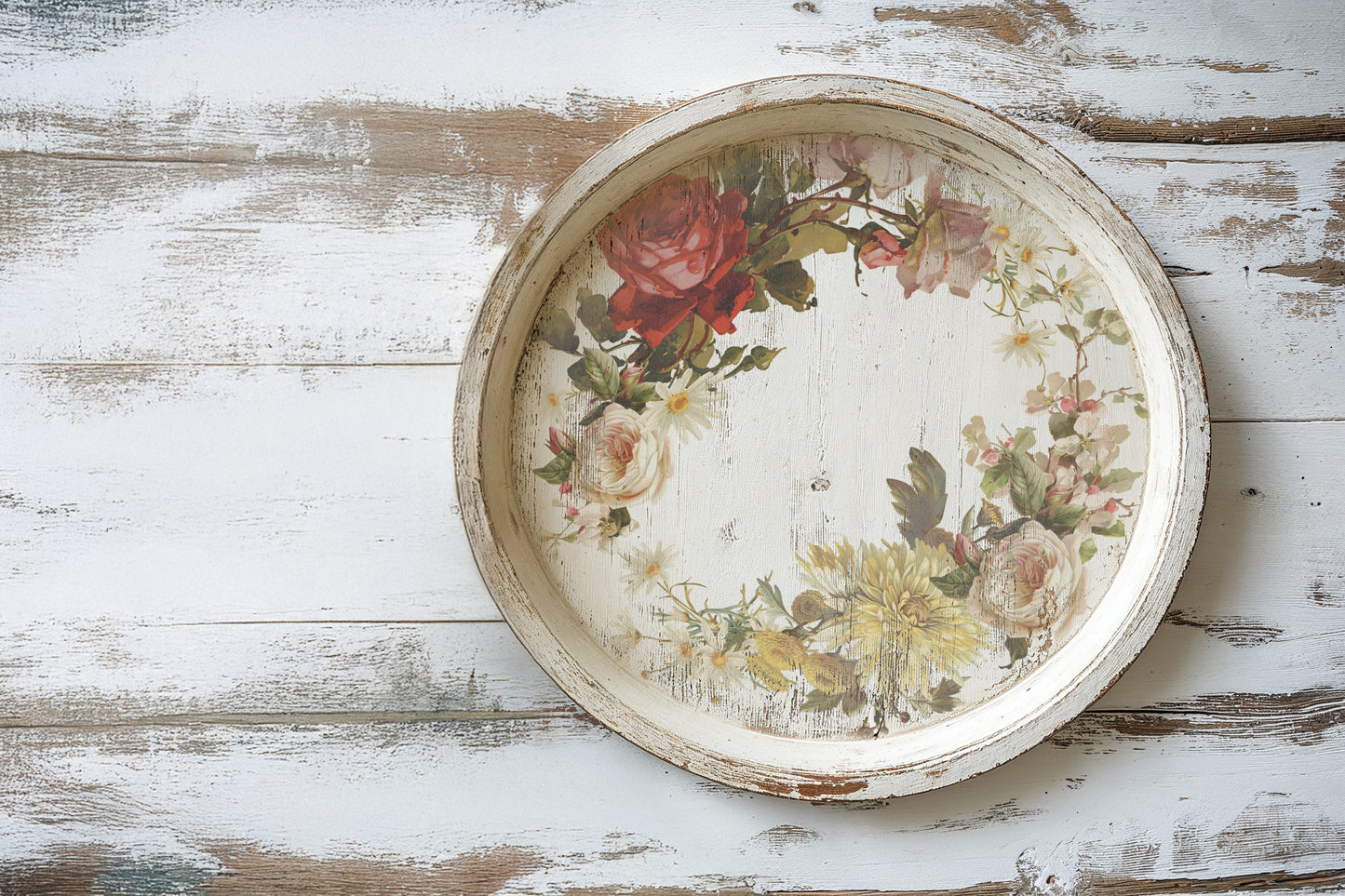 Round decorative tray with floral design on a wooden surface