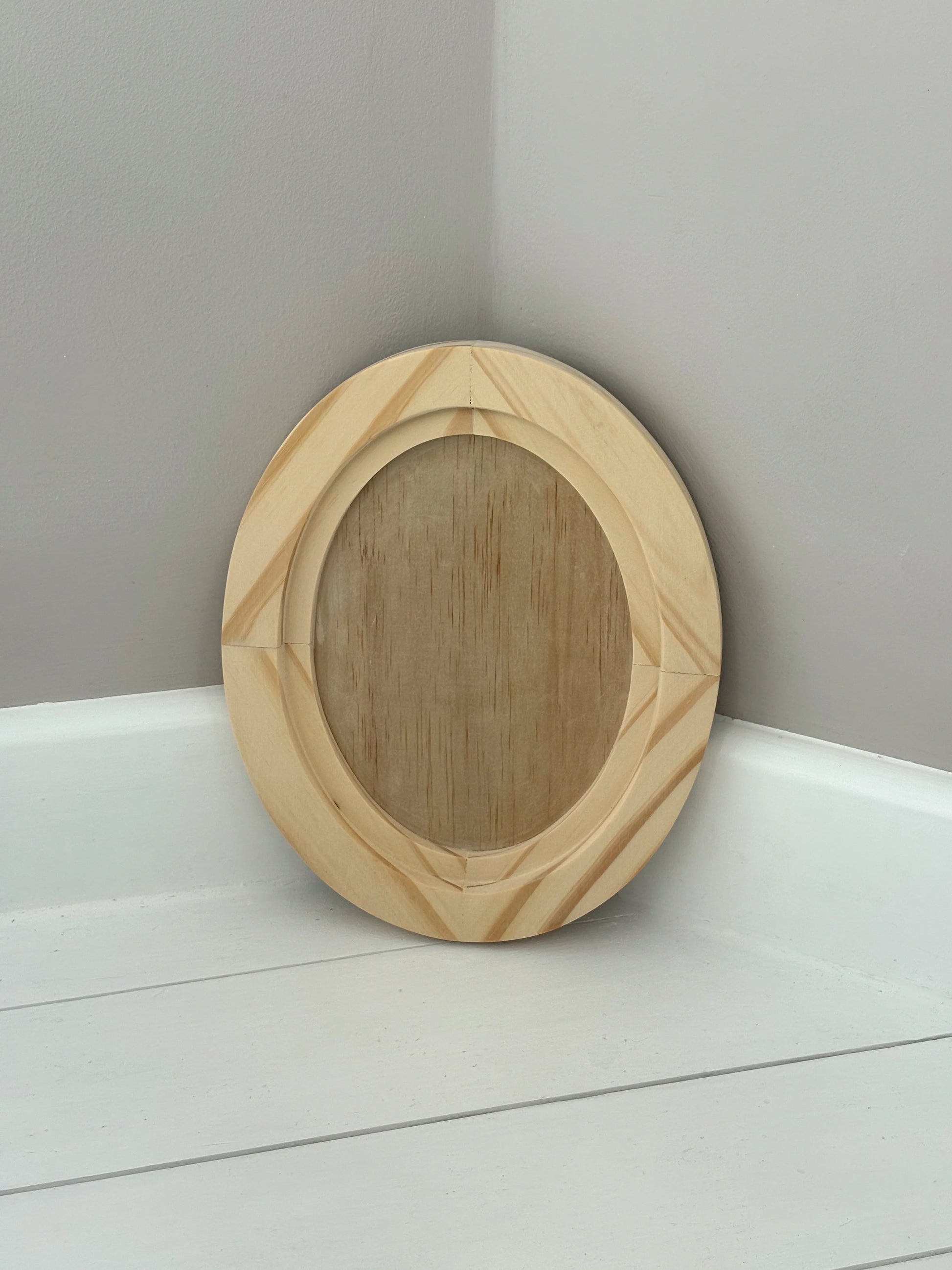 Wooden circular object on a white surface with a gray background