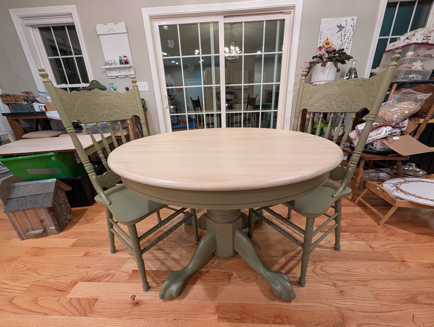 Round wooden dining table with four chairs in a home setting