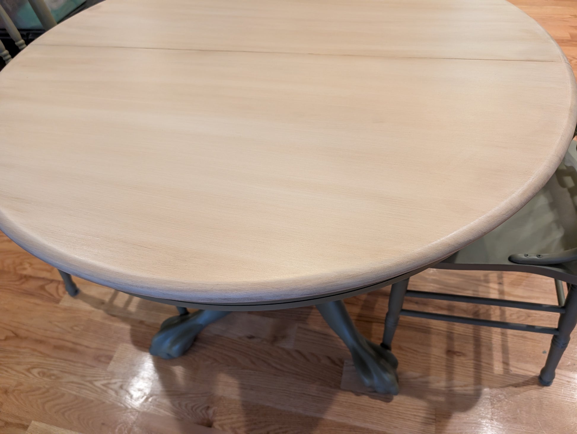 Round wooden table with metal legs on a wooden floor