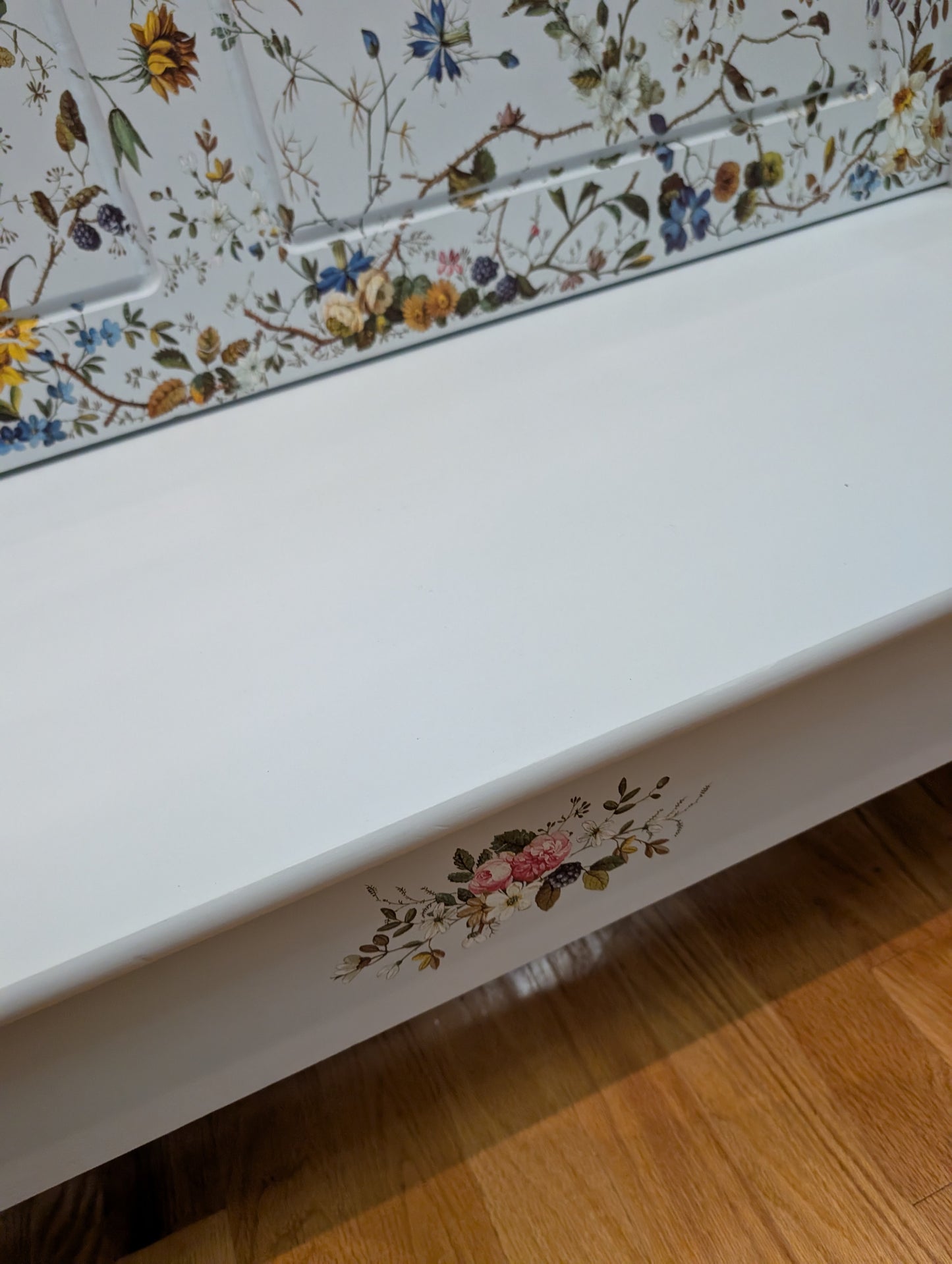 White surface with floral decal on a wooden floor